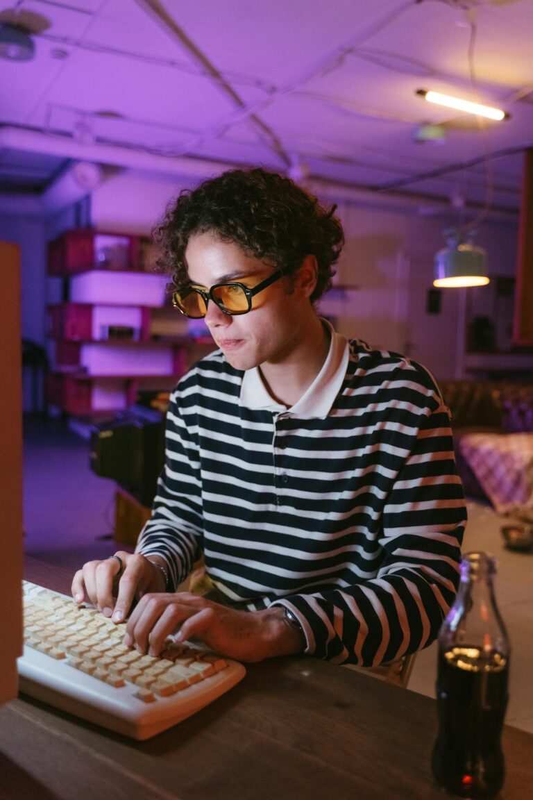 Teenager typing on vintage keyboard in a retro-themed room with neon lighting.